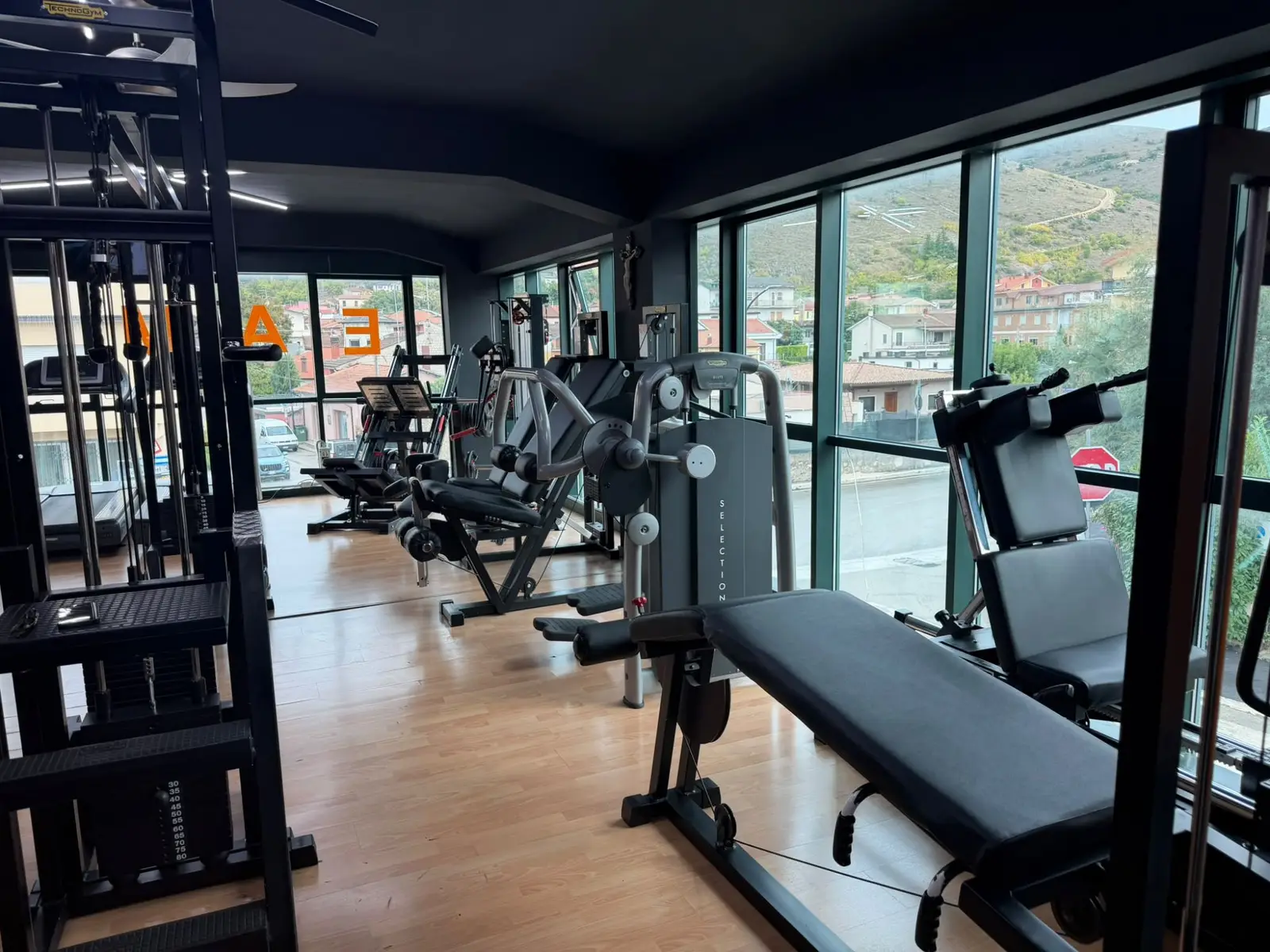 Le macchine per l'allenamento muscolare davanti alle vetrate, con vista sulle montagne